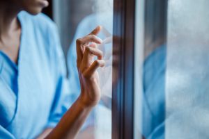 black-woman-touches-window-in-hospital