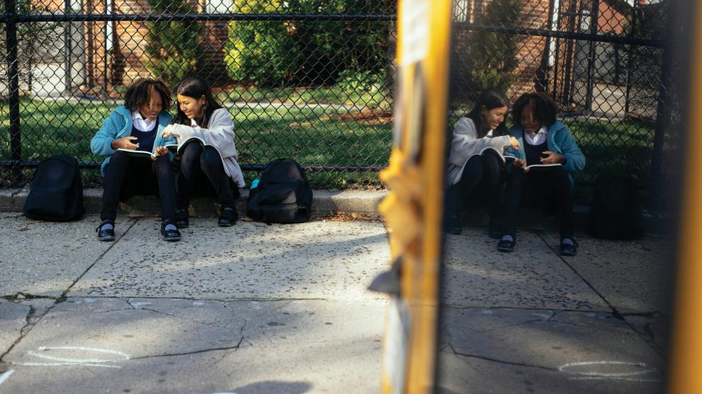 two-school-children-waiting-for-bus