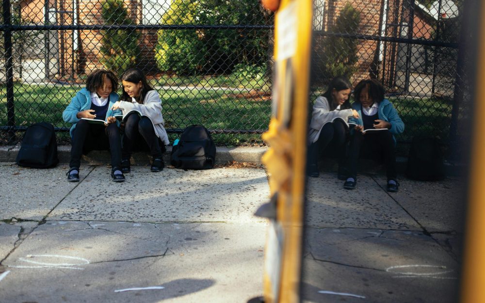 two-school-children-waiting-for-bus