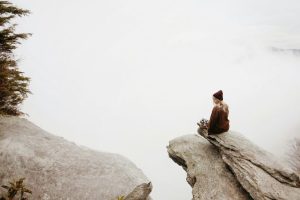 woman sitting-alone-on-cliff