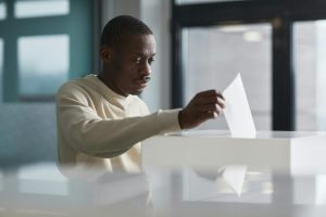 man-submitting-ballot-at-voting-booth