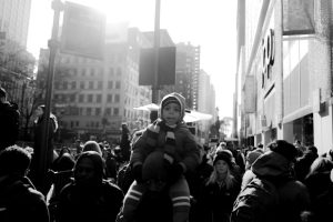 man-holding-child-on-shoulders-in-crowd