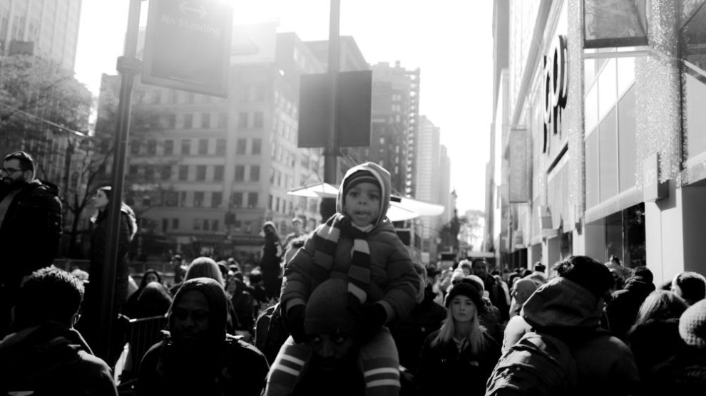 man-holding-child-on-shoulders-in-crowd