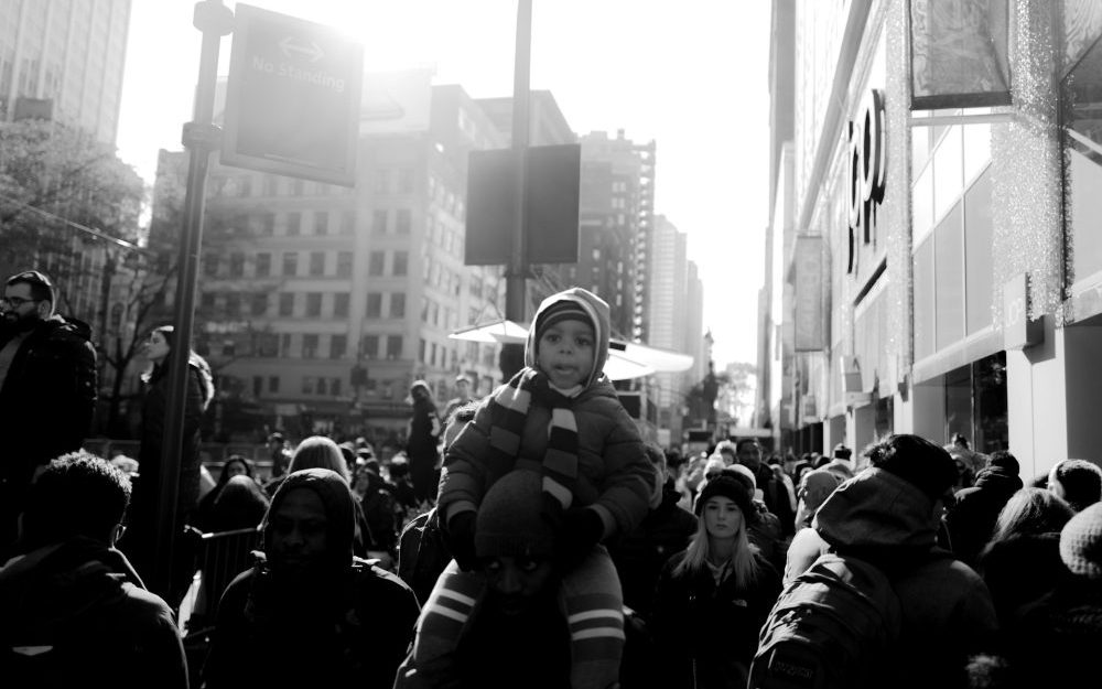 man-holding-child-on-shoulders-in-crowd