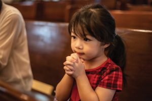 u-s-catholic-young-girl-praying-in-pews