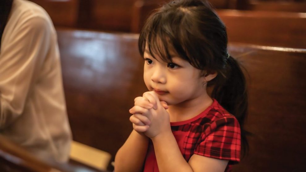 u-s-catholic-young-girl-praying-in-pews