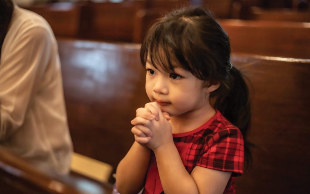 u-s-catholic-young-girl-praying-in-pews