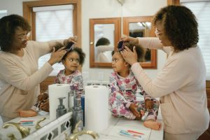 u-s-catholic-mother-brushing-daughters-hair