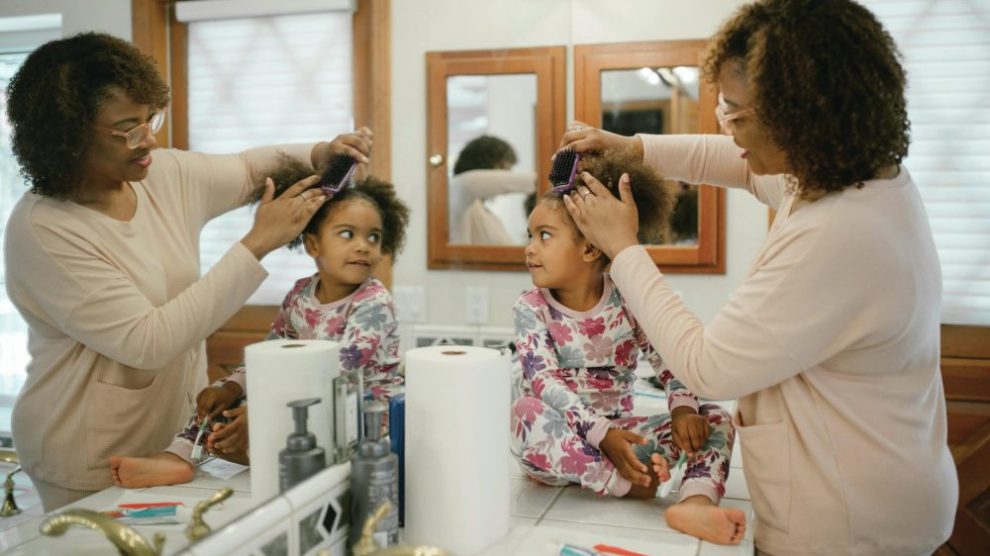 u-s-catholic-mother-brushing-daughters-hair