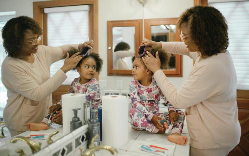 u-s-catholic-mother-brushing-daughters-hair
