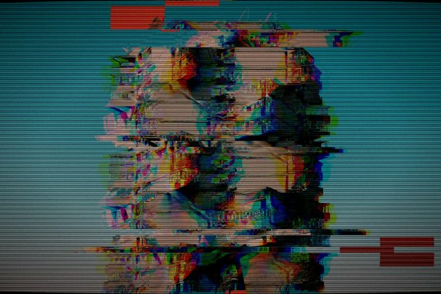 Distorted heads on a glitchy television screen
