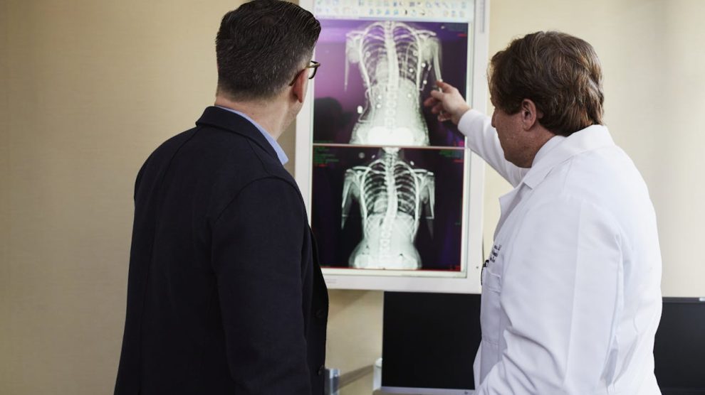 two men look at an xray