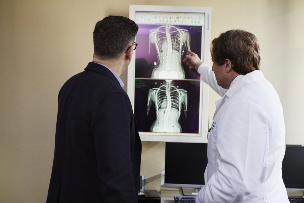 two men look at an xray