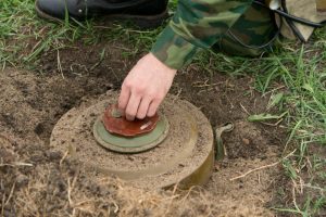 Soldier inspects undetonated landmine