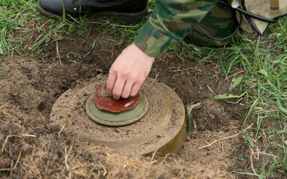Soldier inspects undetonated landmine