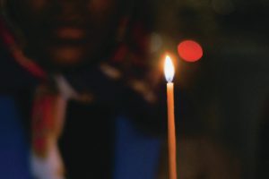 person holding a long lit candle