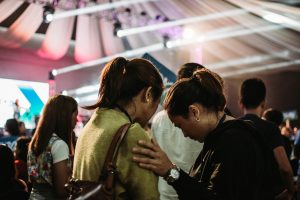 Photo of a woman touching another person's shoulder and looking down