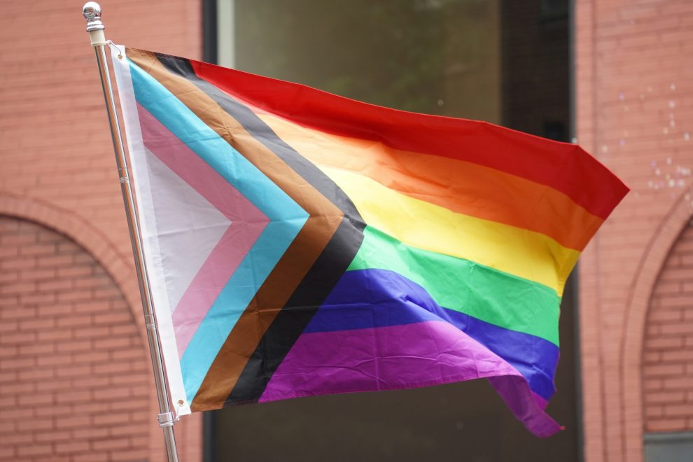 Pride flag in front of brick building