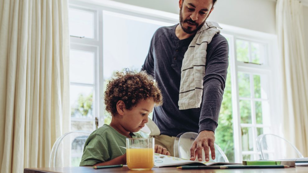 Father making his son do his school home work