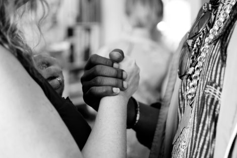 Black person and white person grasping each other's hand