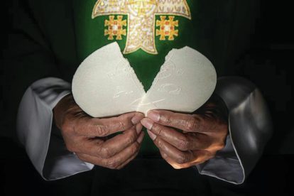 Priest breaking the Eucharit