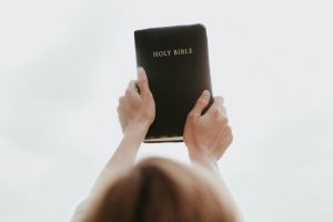 Person lifting Bible into the air