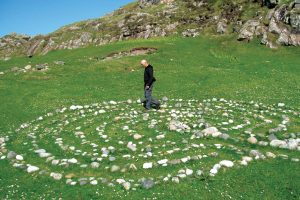 Man walks a labyrinth made out of stones