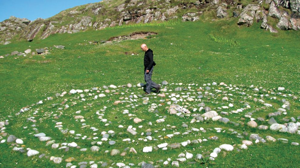 Man walks a labyrinth made out of stones