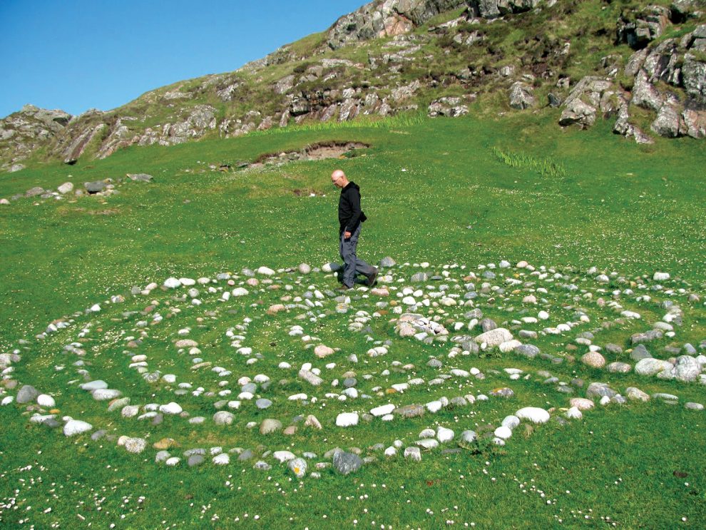 Man walks a labyrinth made out of stones