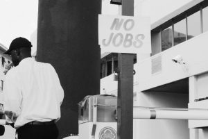 Sign posted in street reading "No Jobs"