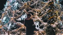 Woman standing alone in front of large holiday display