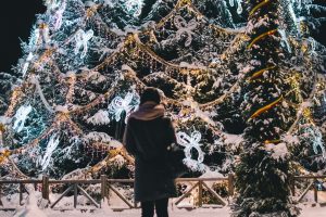 Woman standing alone in front of large holiday display