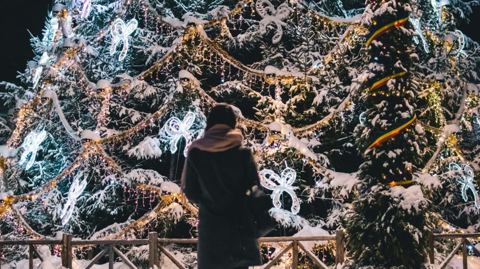 Woman standing alone in front of large holiday display