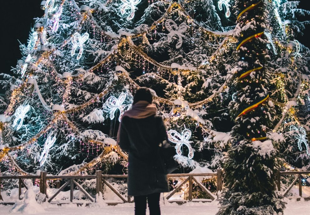 Woman standing alone in front of large holiday display