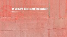 Wall painted with the words "leave no one behind"