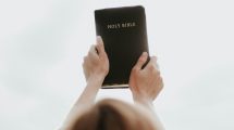 person holding up a bible
