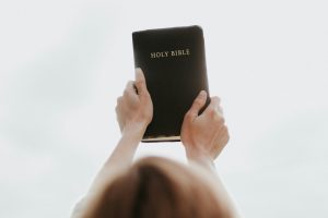 person holding up a bible