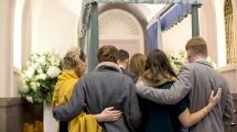 Group of people comforting one another at a funeral