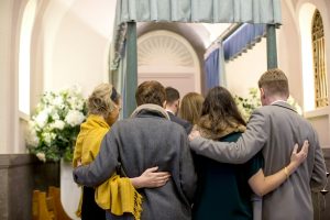Group of people comforting one another at a funeral