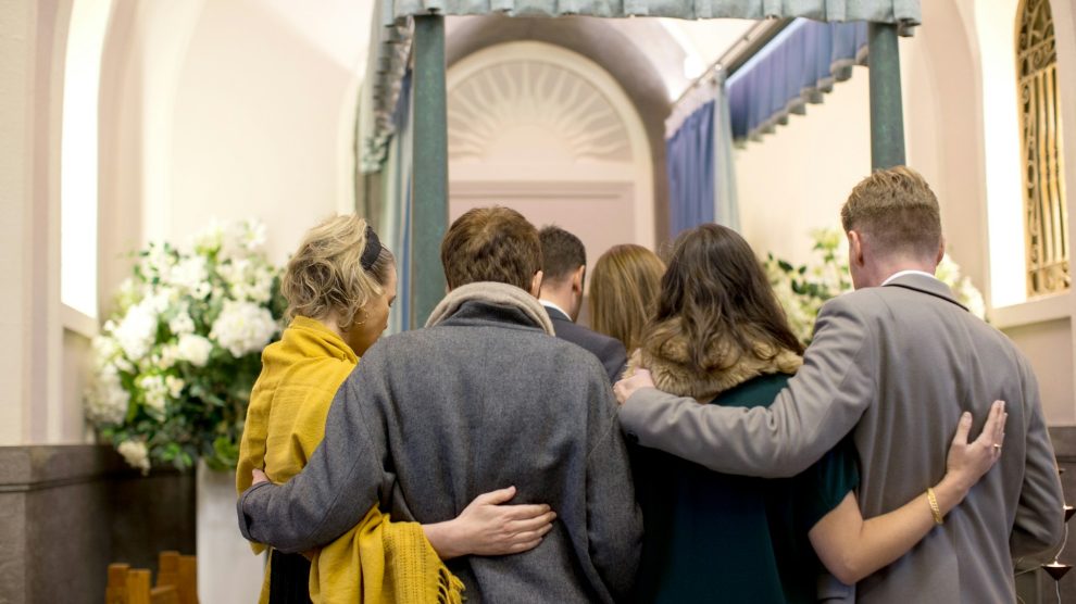 Group of people comforting one another at a funeral