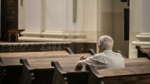 Elderly person sitting alone in a pew