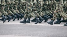 Soldiers marching in formation wearing camouflage