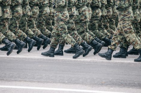 Soldiers marching in formation wearing camouflage