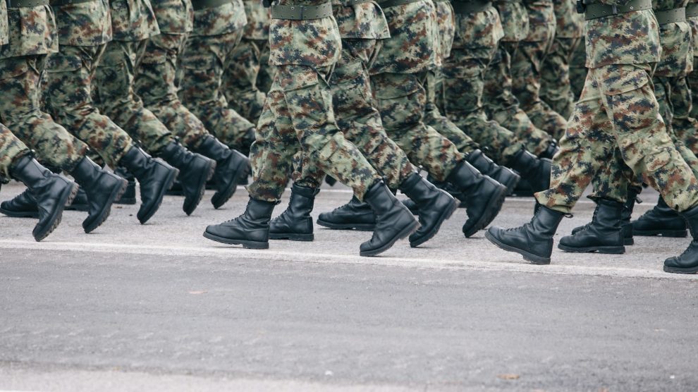 Soldiers marching in formation wearing camouflage