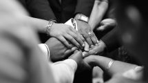 group of hands united in prayer