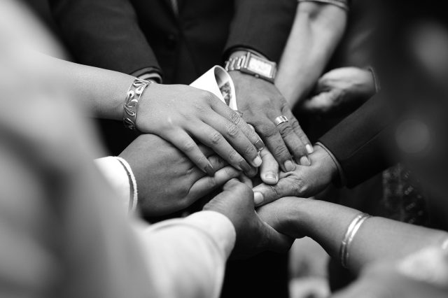 group of hands united in prayer