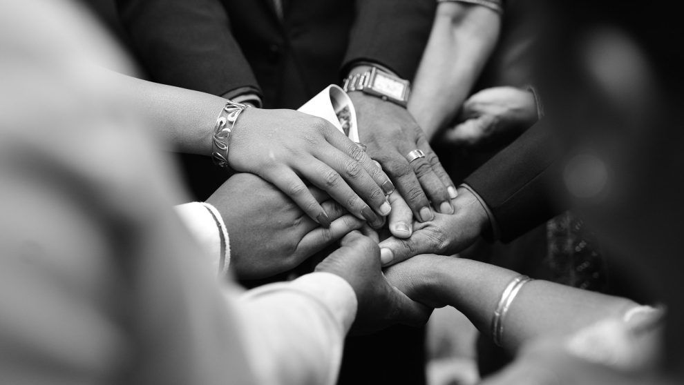 group of hands united in prayer