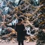 Woman standing alone in front of large holiday display