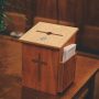 a wooden church offering box suggesting the ease of church embezzlement - U.S.S catholic