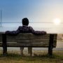 person-sitting-on-bench-by-water